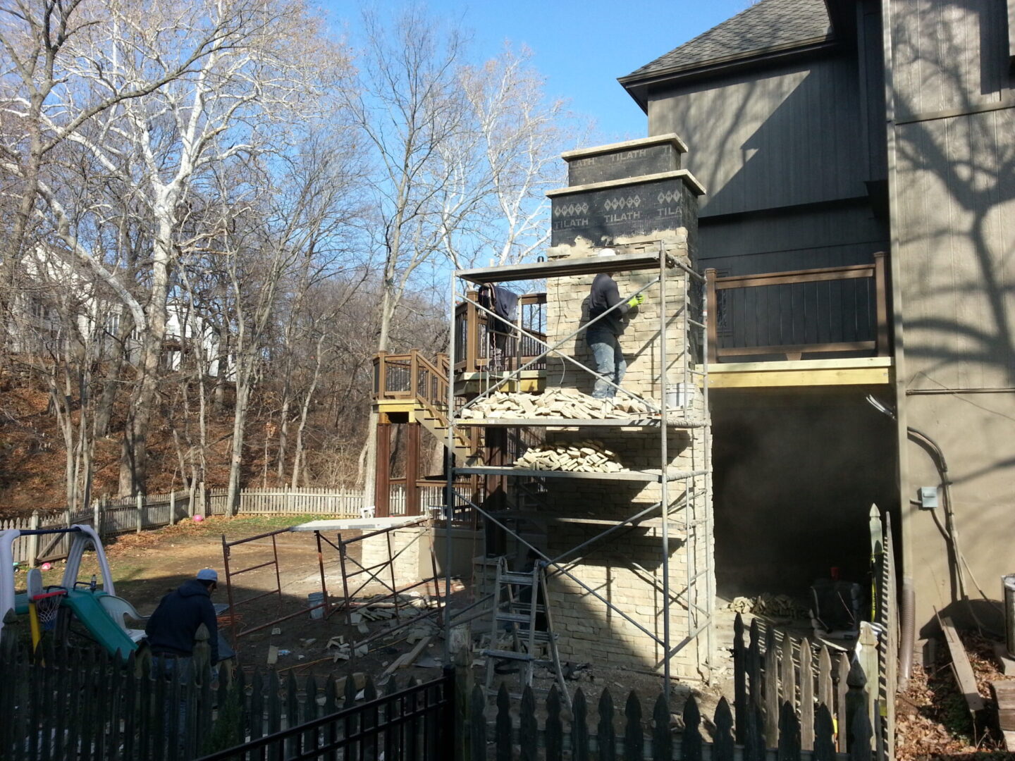 A house under renovation with scaffolding on the balcony.