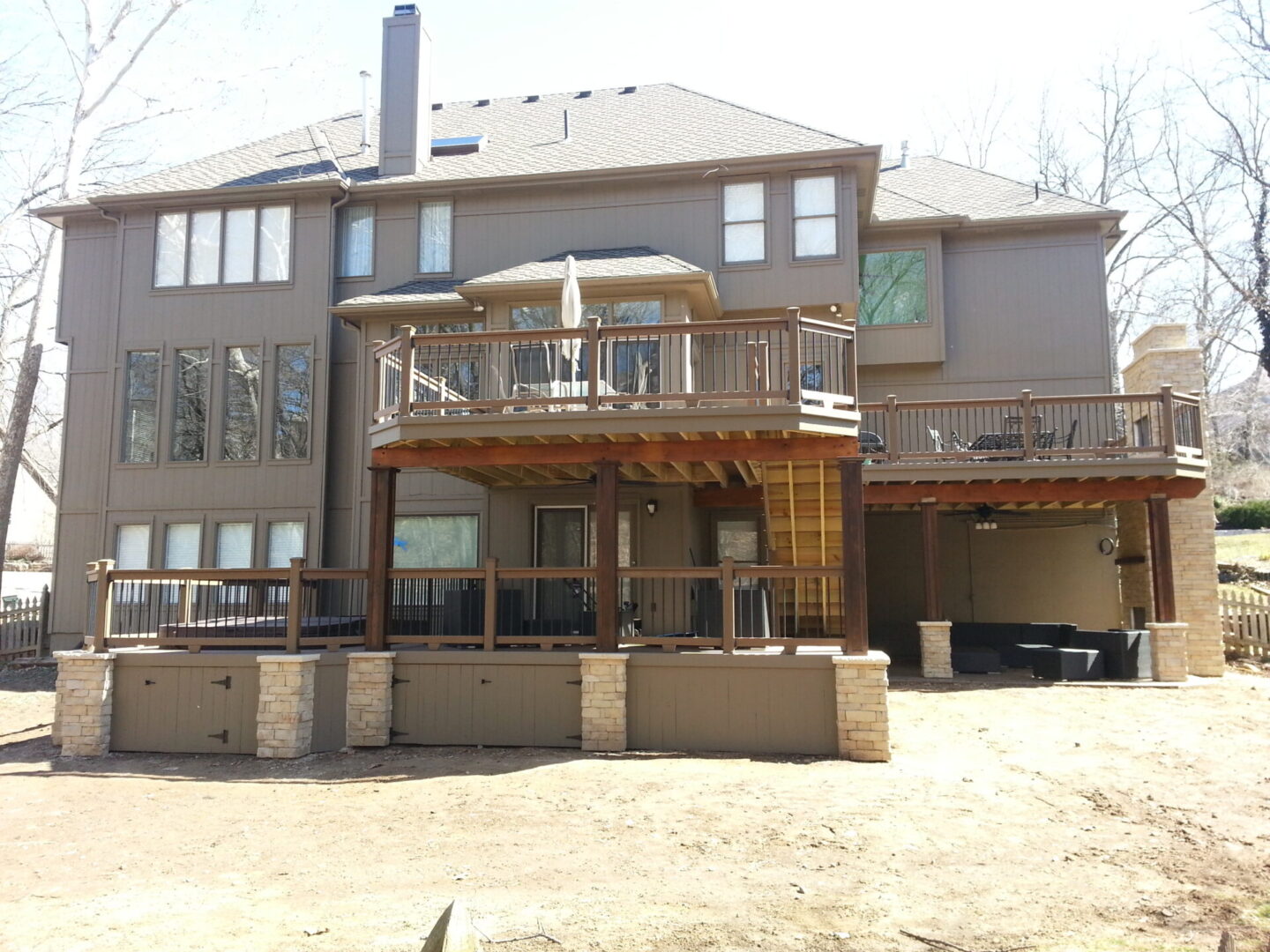 Large modern house with a spacious wooden deck and patio.