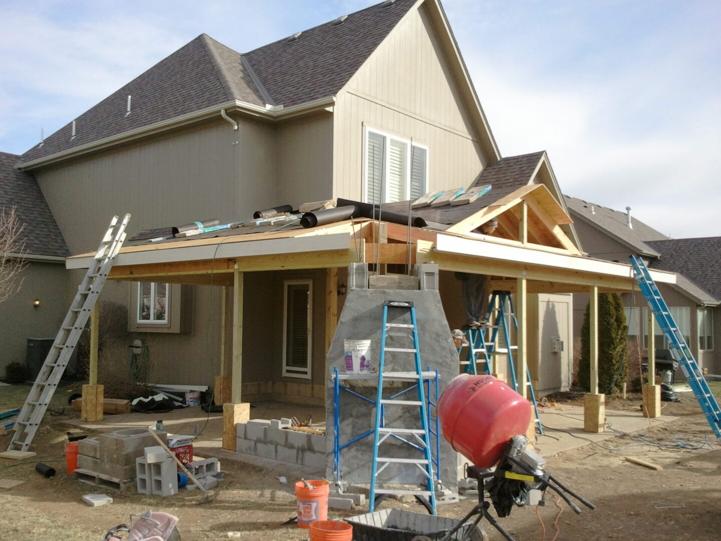 House patio roof under construction with ladders