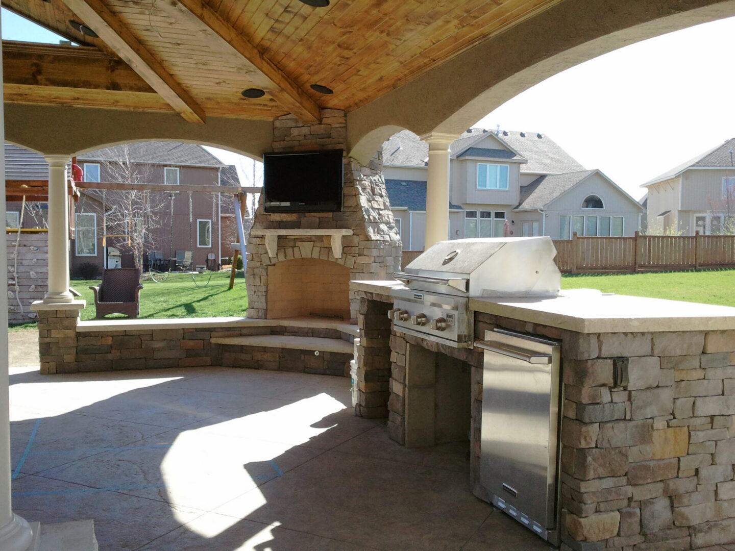 Covered patio with stone fireplace and grill