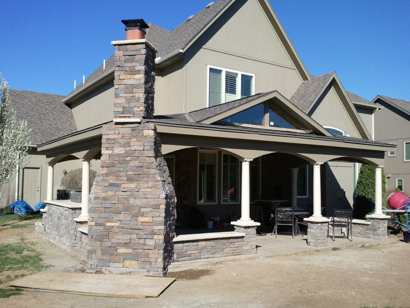 Backyard patio with stone chimney and columns