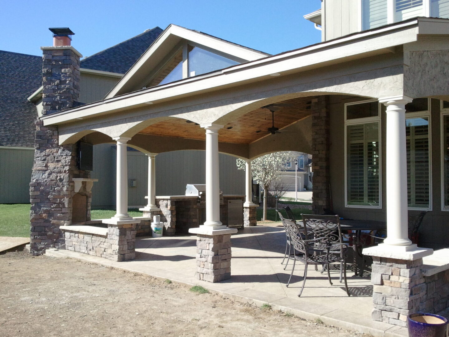 Covered patio with columns and stone fireplace