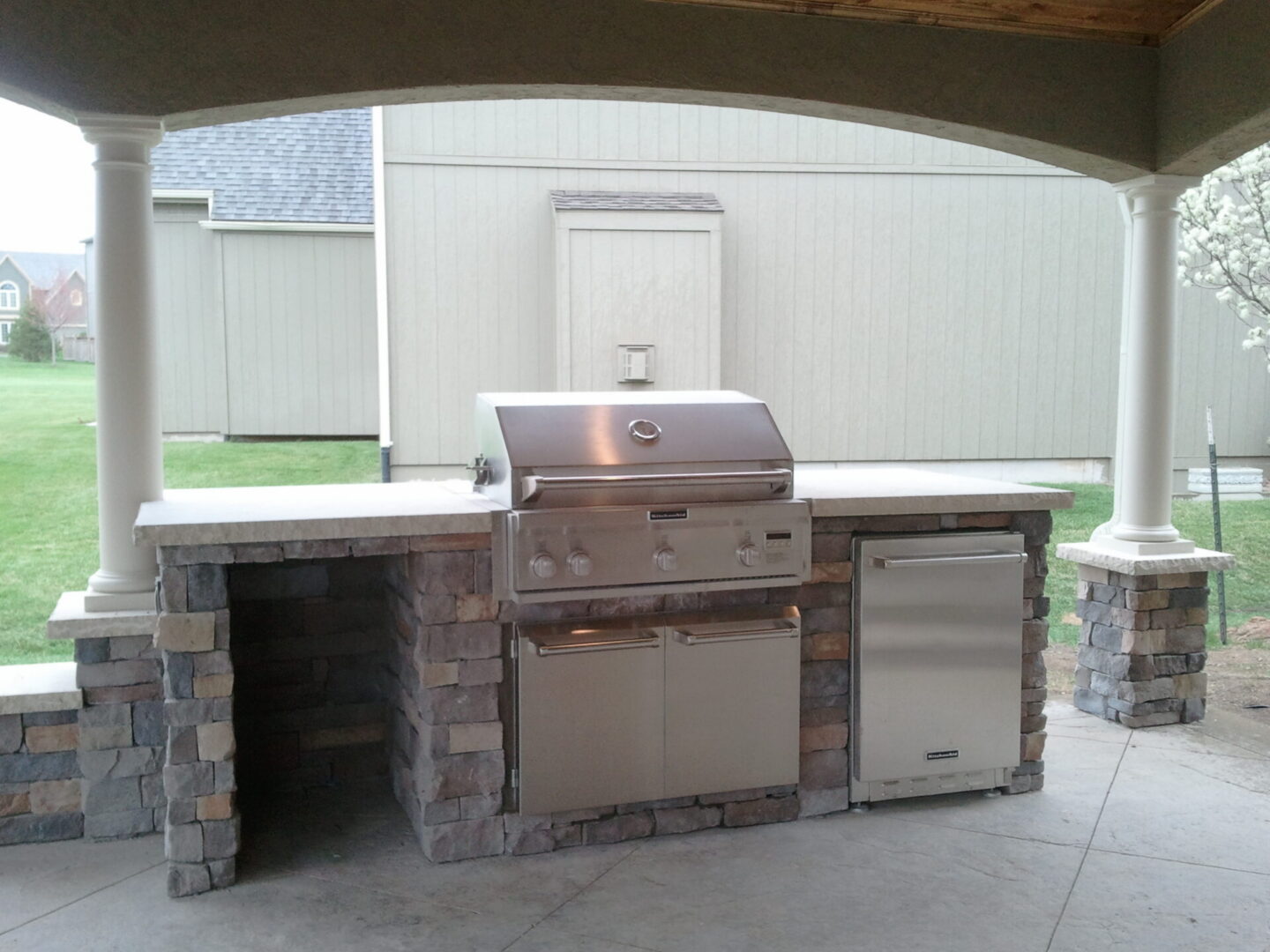 Covered outdoor kitchen with stainless steel grill