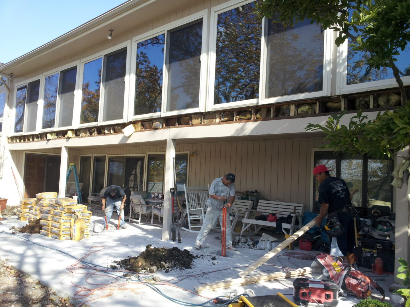 Patio renovation crew working on house exterior