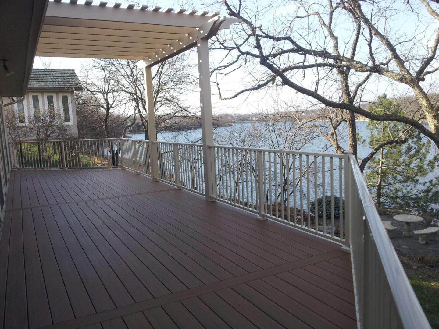 Spacious lakeside deck with pergola and railing