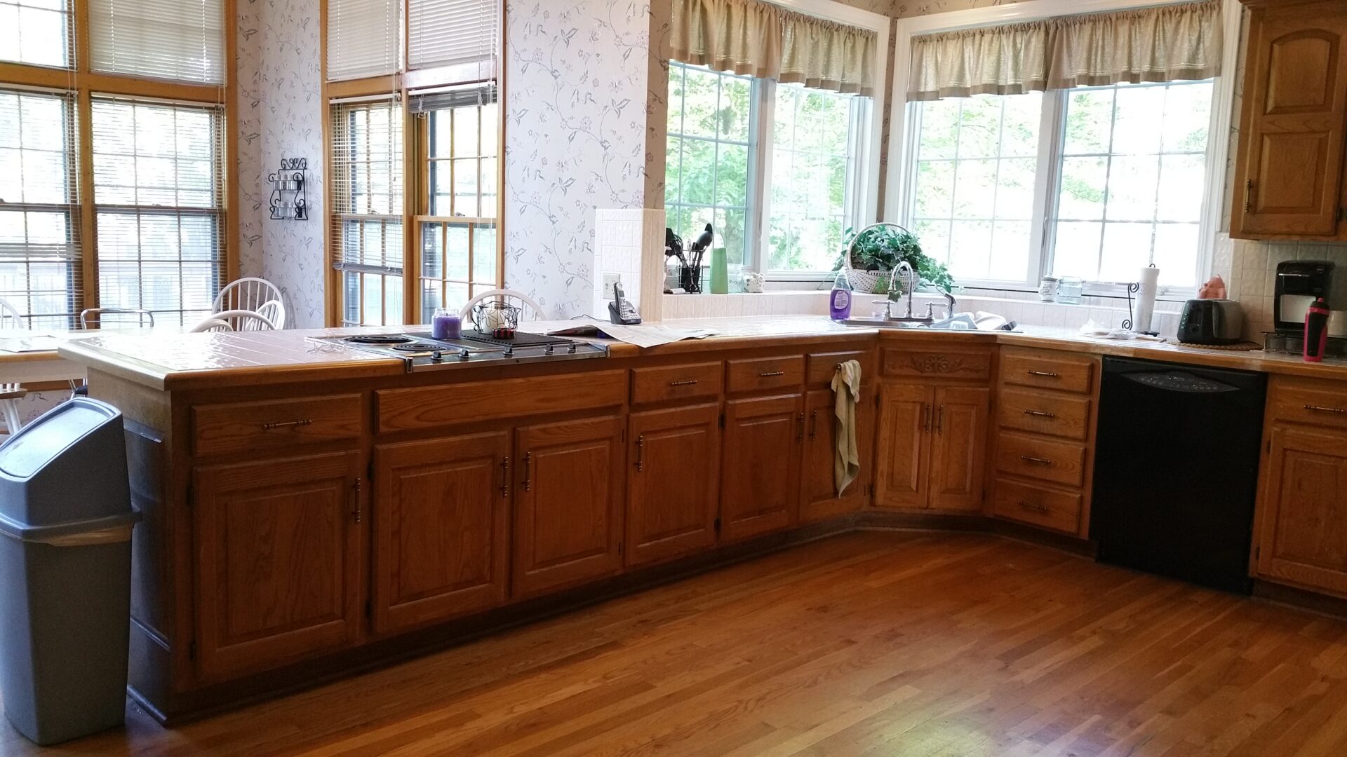 Sunlit kitchen with wooden cabinets and corner sink