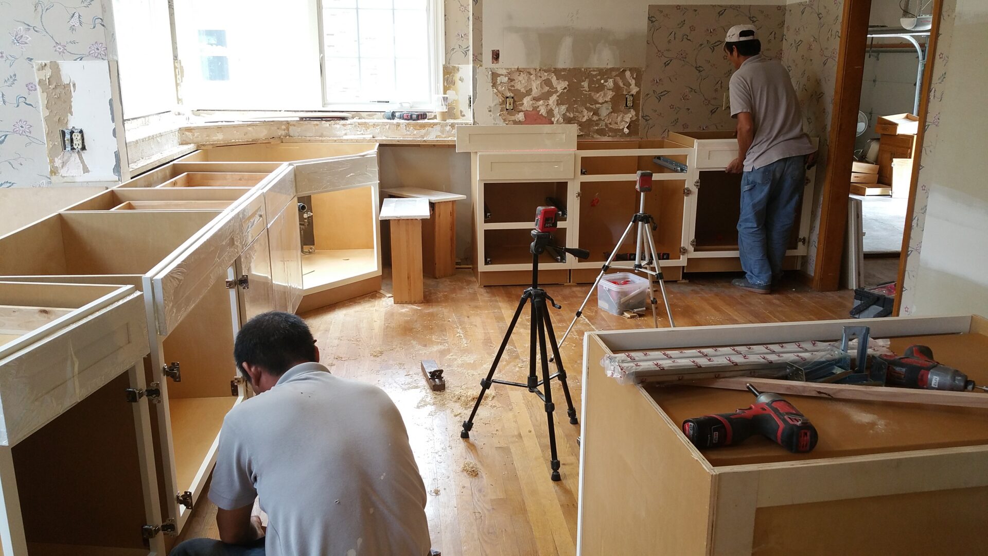 Two workers installing kitchen cabinets