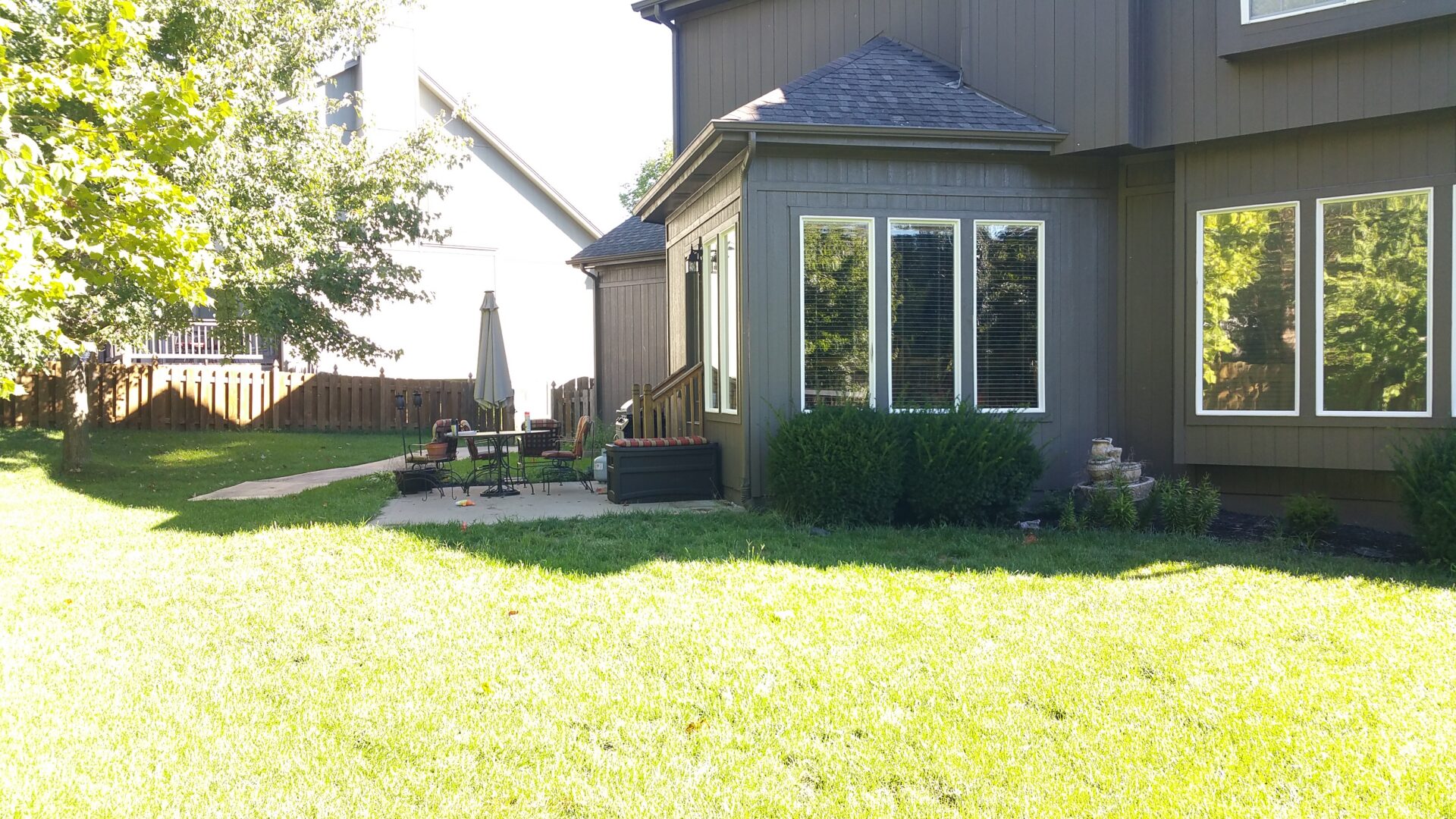 Suburban backyard with patio and green lawn