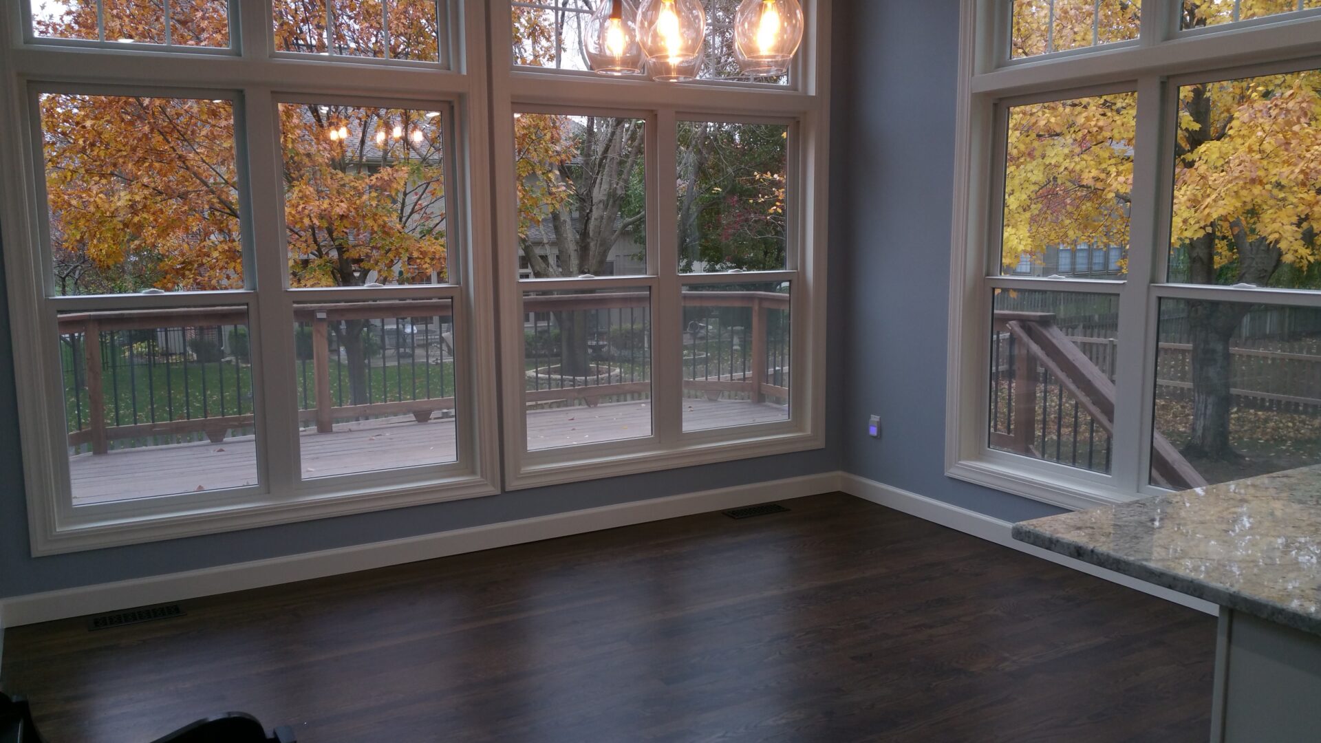 Empty room with large windows overlooking autumn trees
