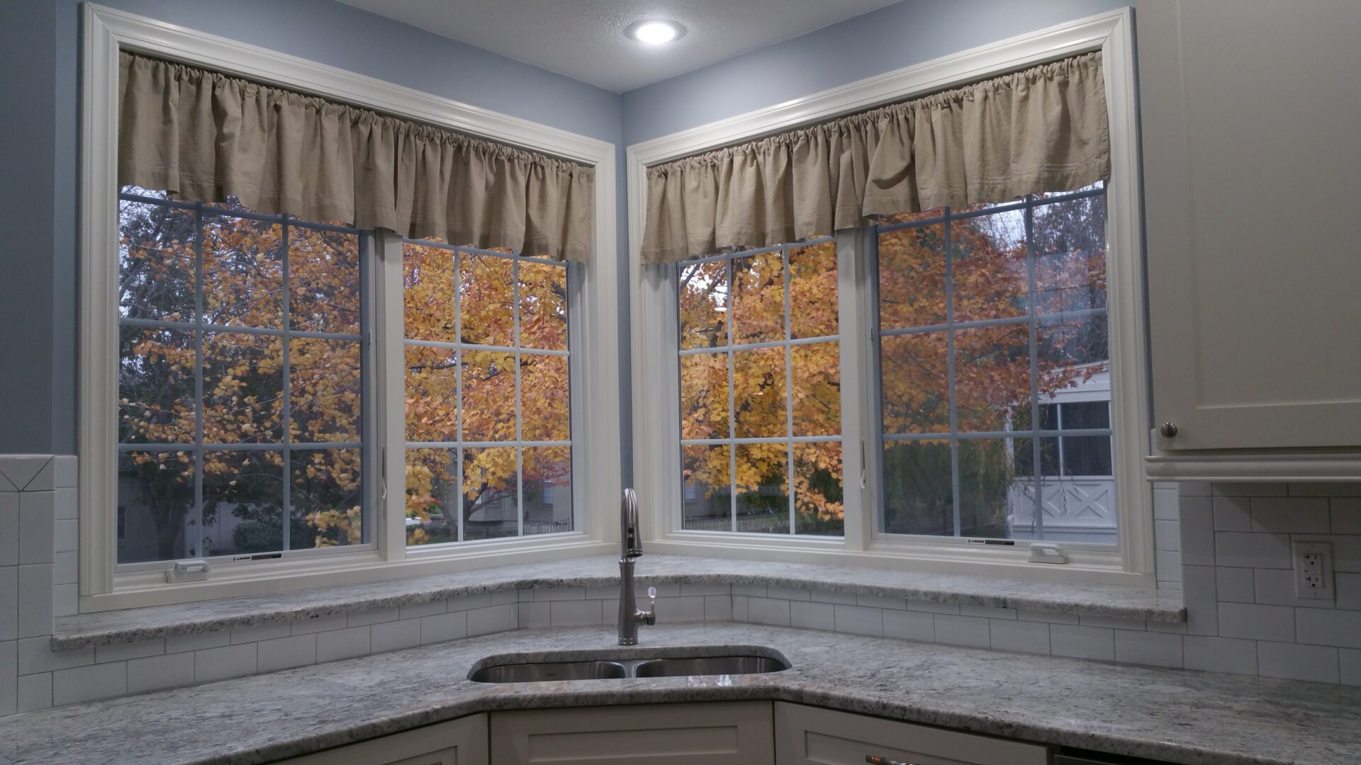 Kitchen sink under bay windows with autumn foliage