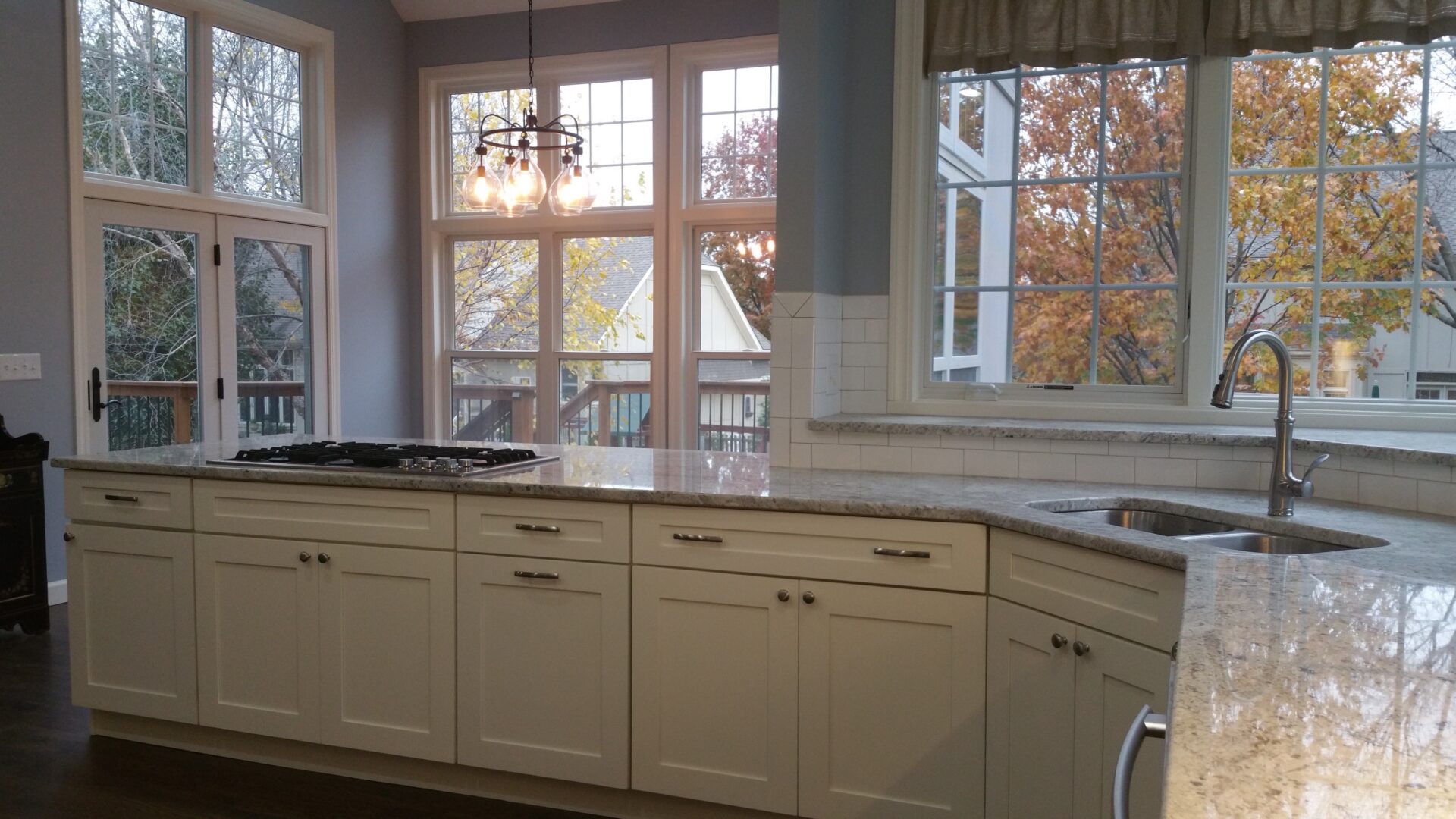 Bright kitchen with white island and large windows