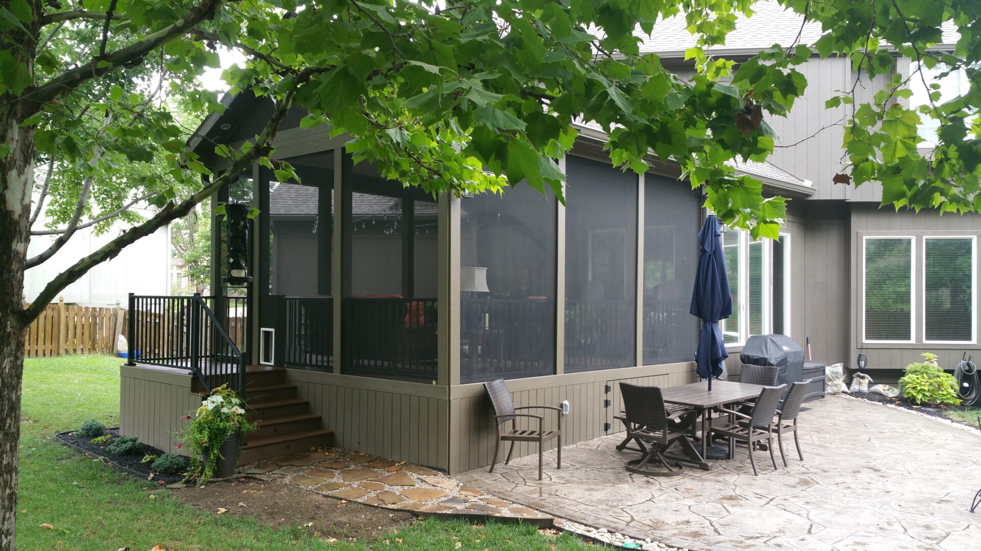 Backyard patio with screened porch and furniture