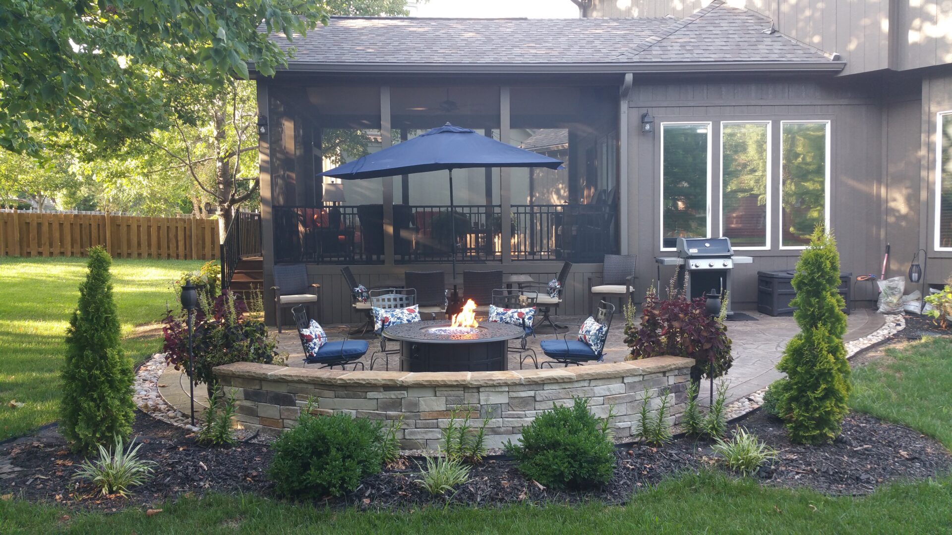 Backyard patio with fire pit and umbrella