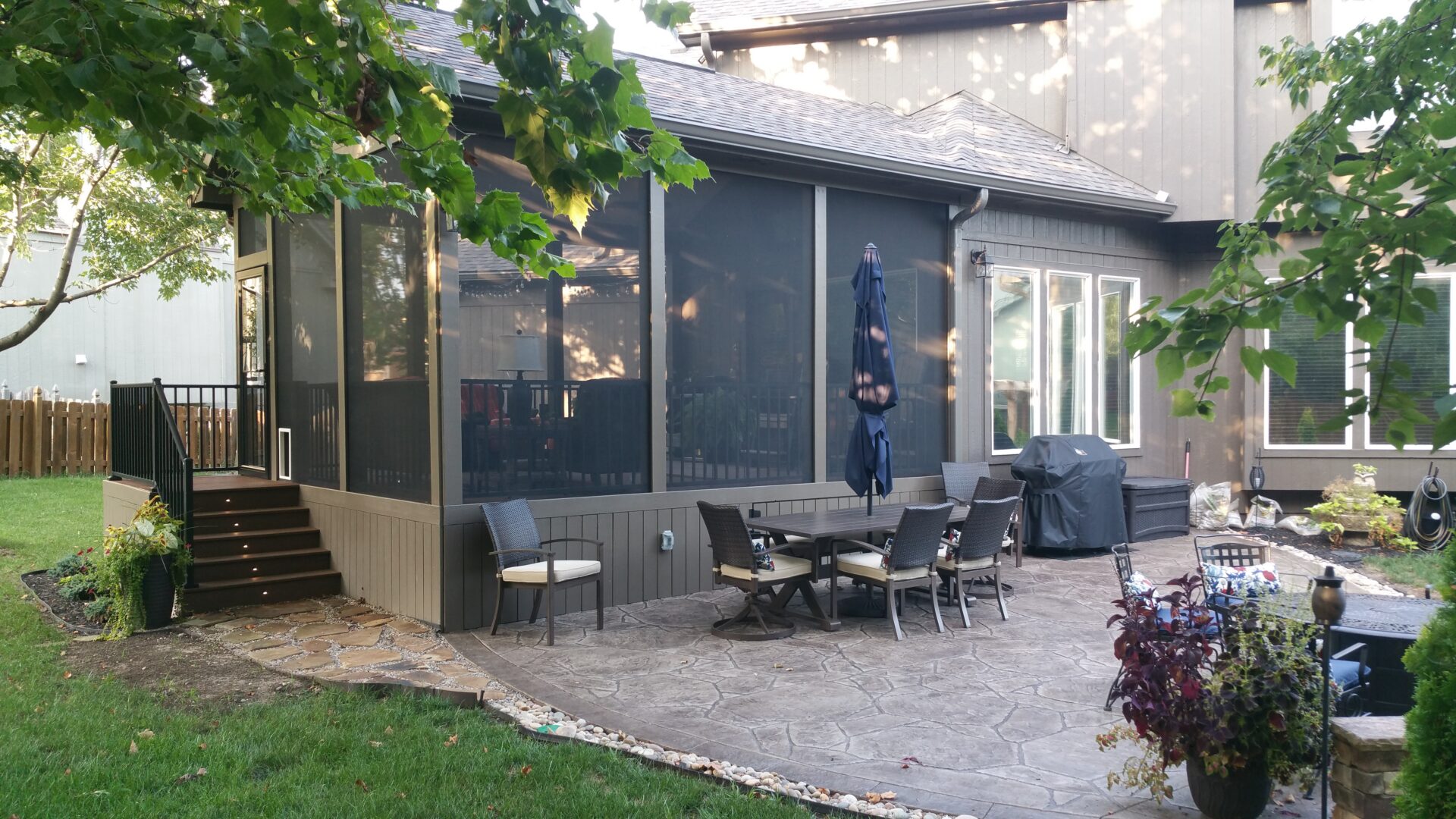 Backyard patio with screened porch, dining set, grill