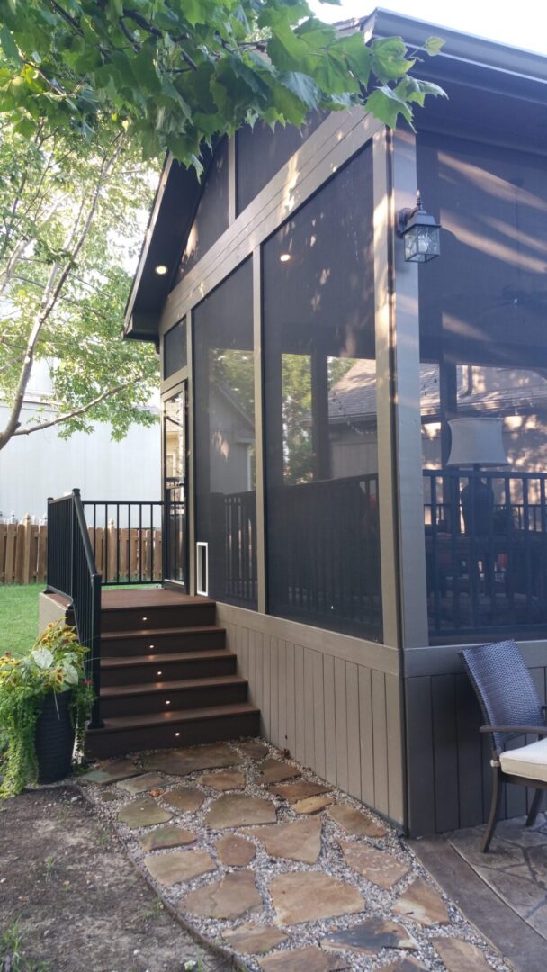 Brown screened porch with steps and stone path
