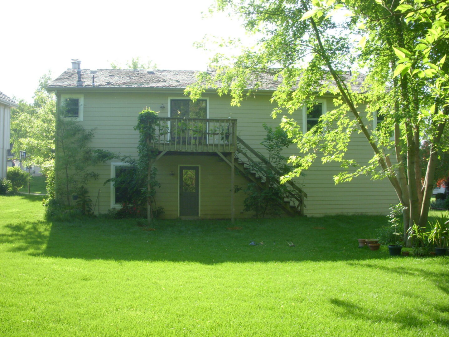 Backyard of house with deck and stairs