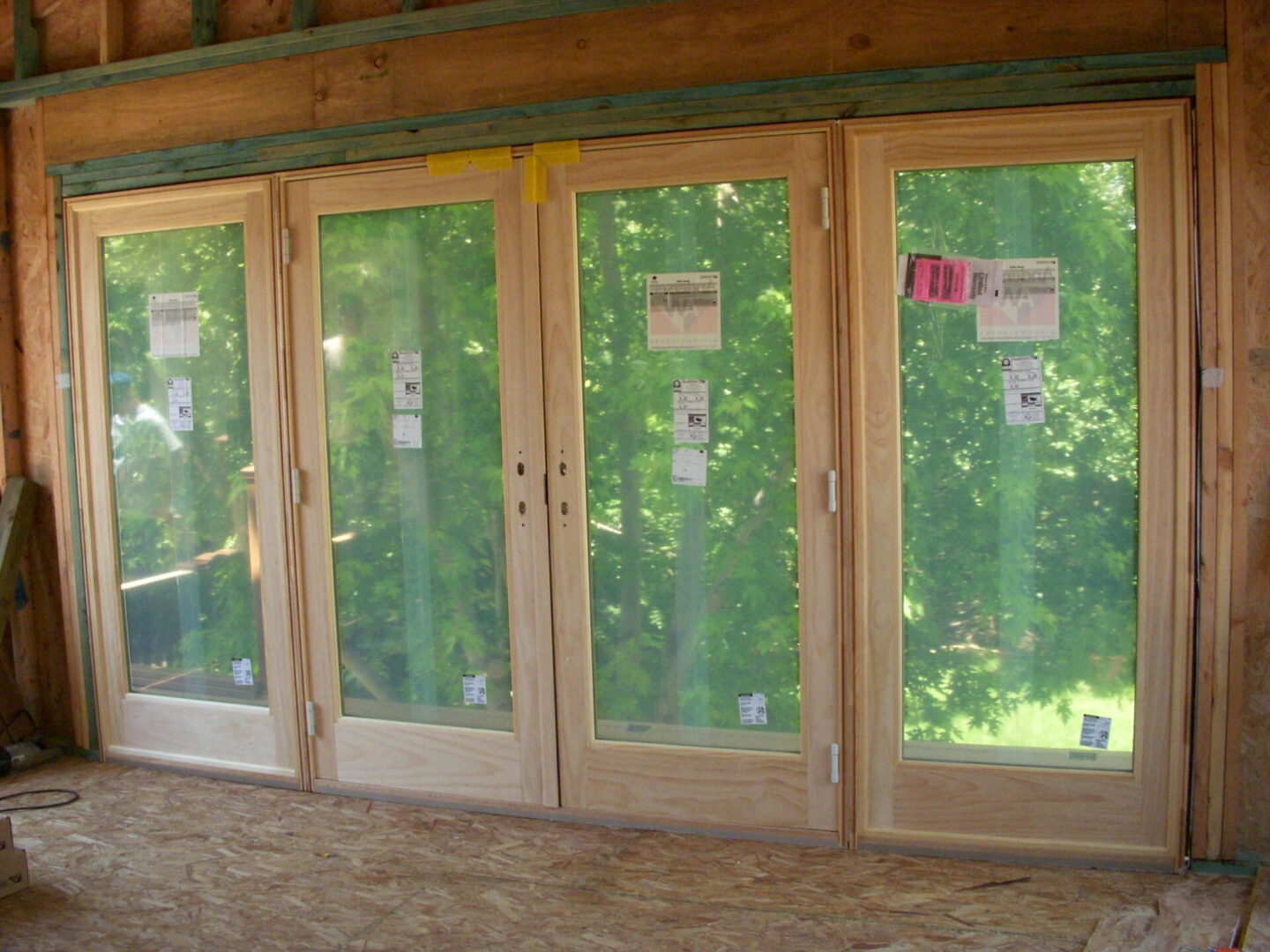 Four panel wooden patio doors overlooking green yard