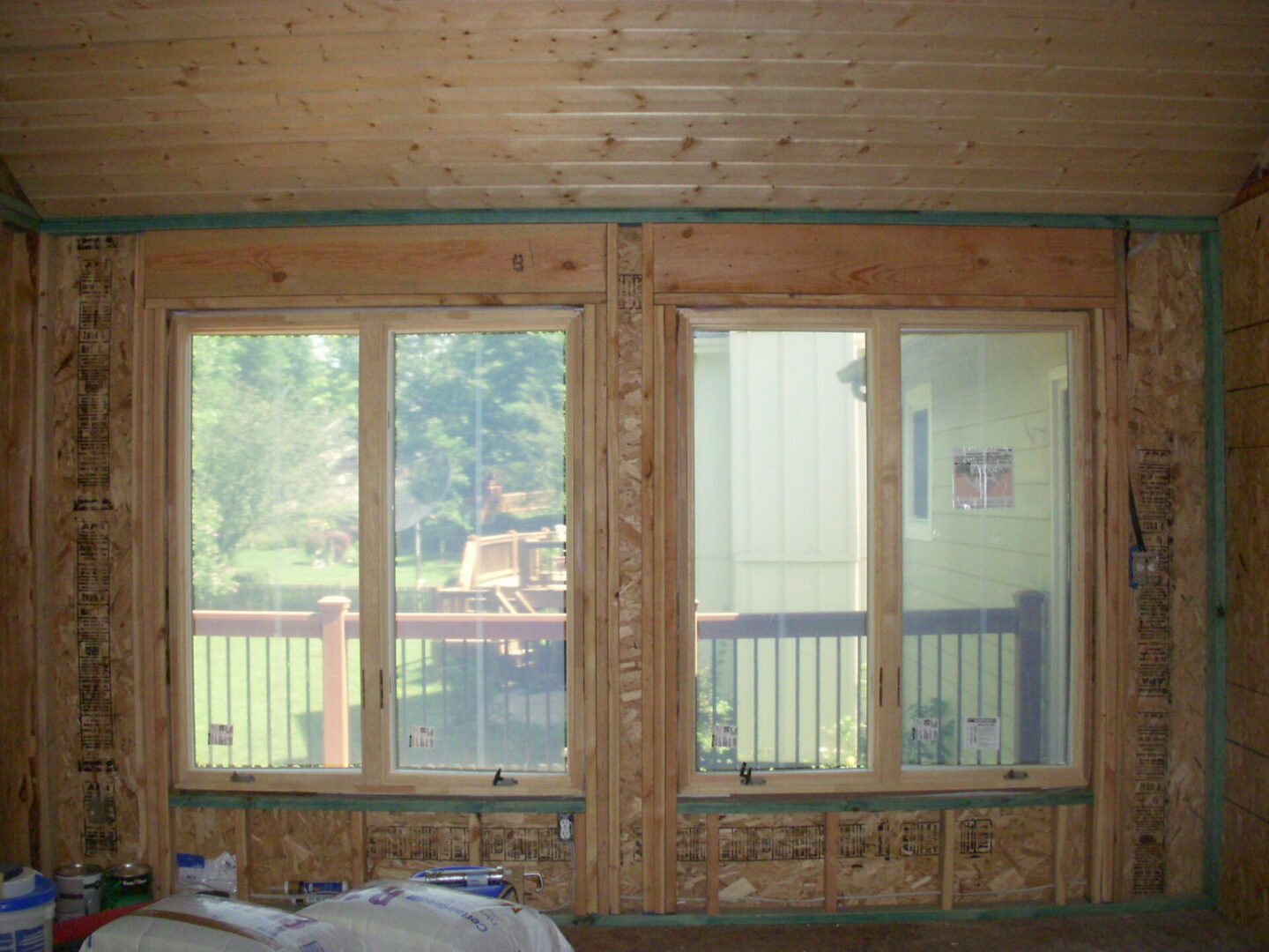 Two windows in unfinished wood-framed room