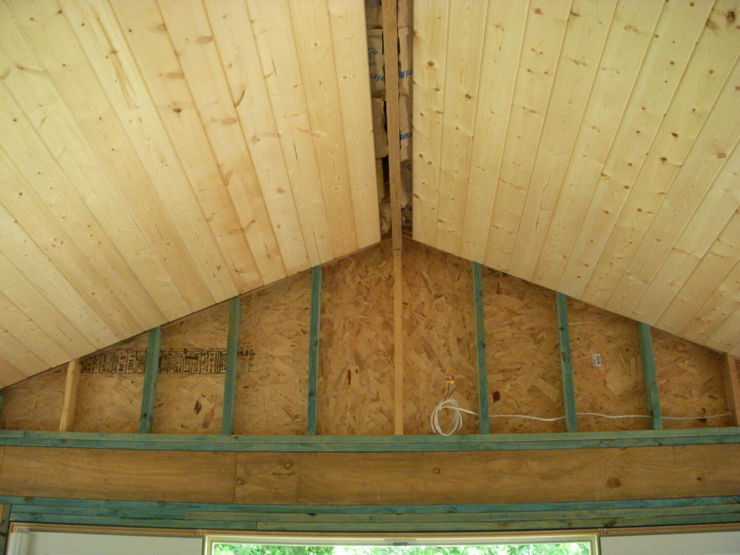 Unfinished vaulted wooden ceiling with exposed studs