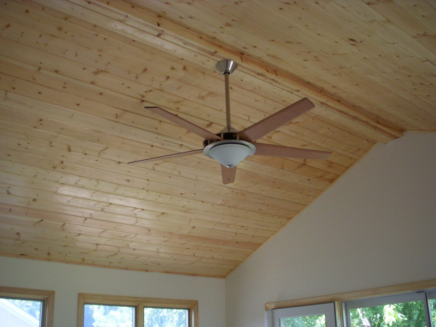 Ceiling fan on wooden plank vaulted ceiling