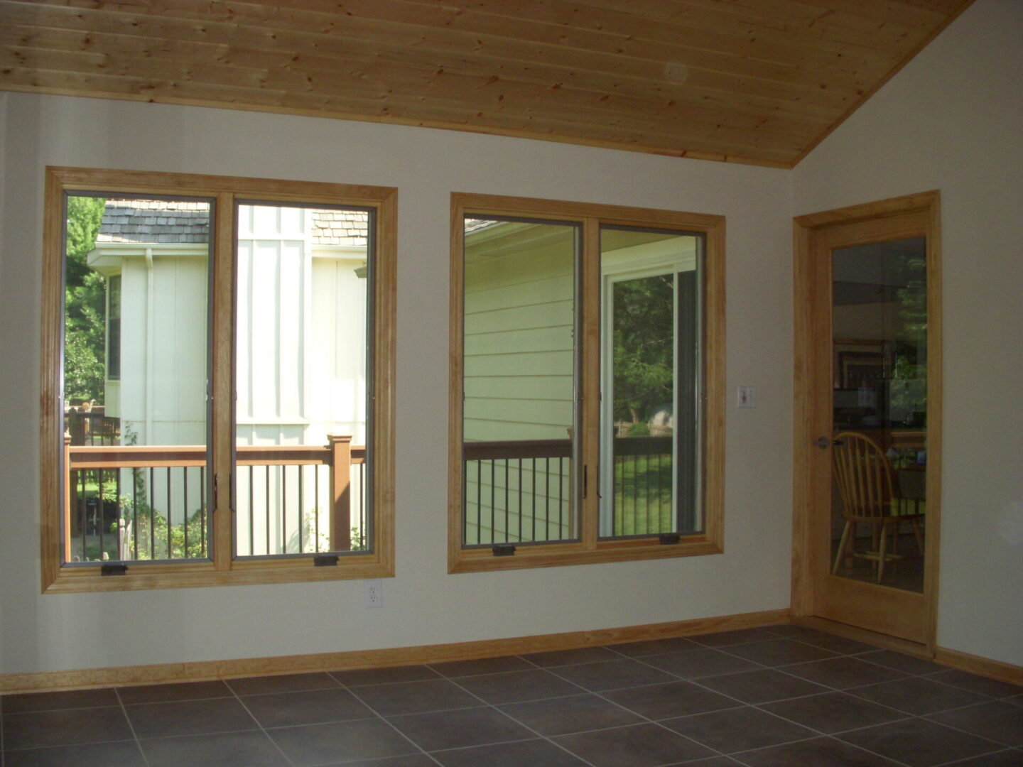 Room with large wood-trim windows and door