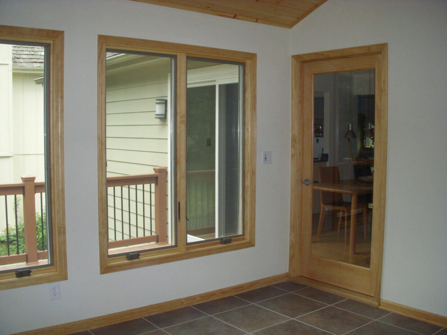 Empty room with wooden-trim windows and door