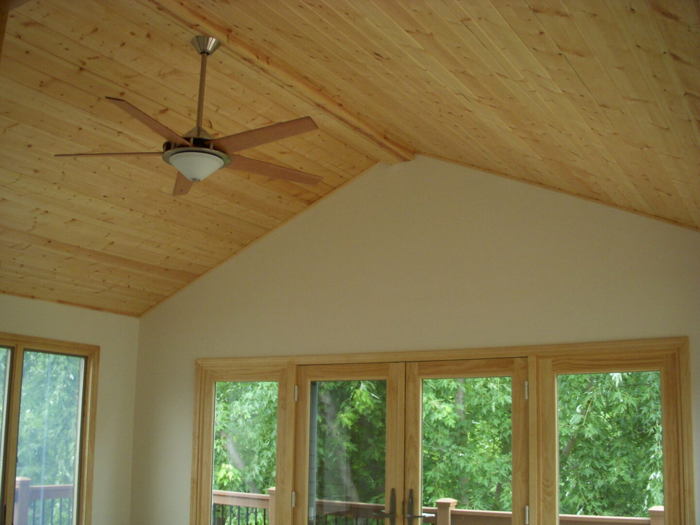 Room with vaulted wood ceiling and fan