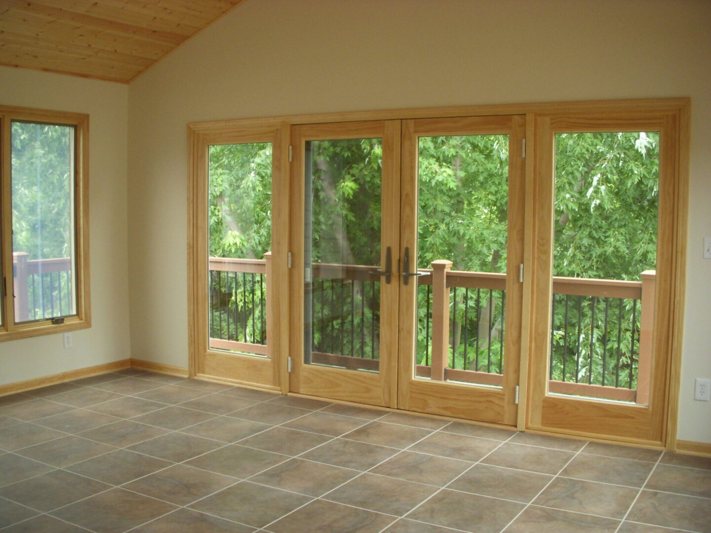 Empty tiled room with French doors to balcony