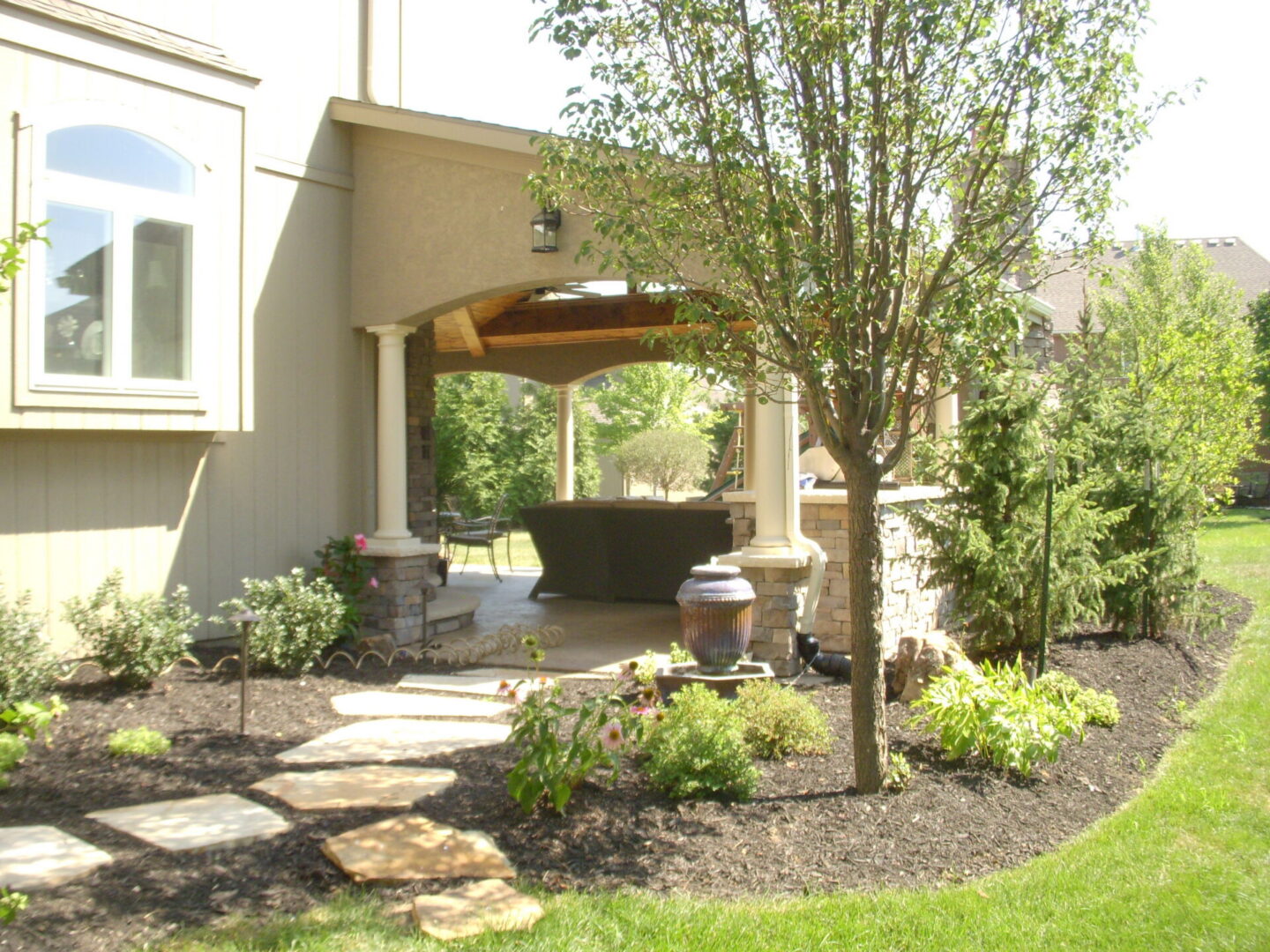Backyard covered patio with stone pathway
