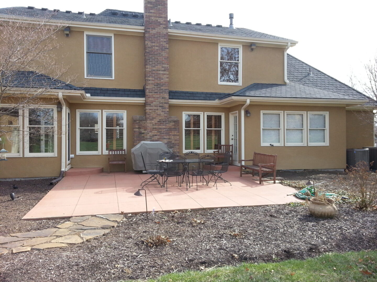 Backyard patio with table, chairs, and grill