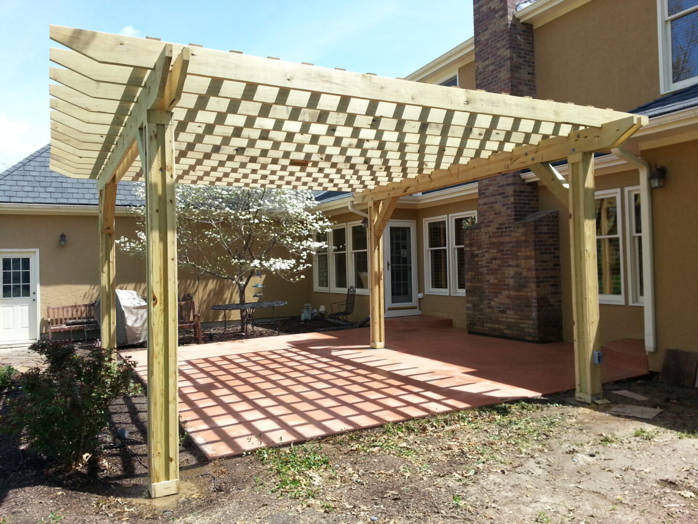 Attached wooden pergola over backyard patio