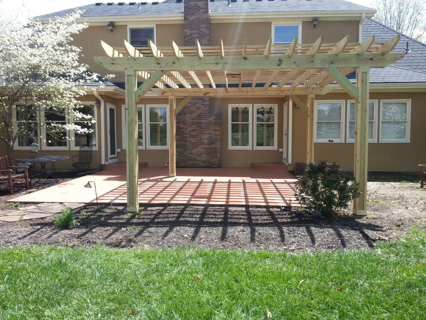 Wooden pergola casting shadows on patio