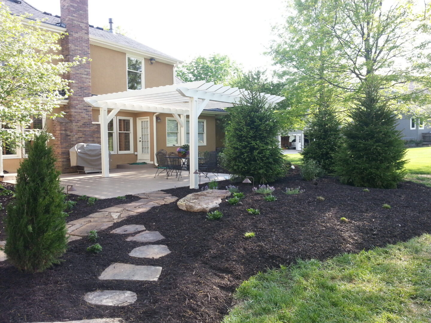 Backyard pergola patio with stepping stone path