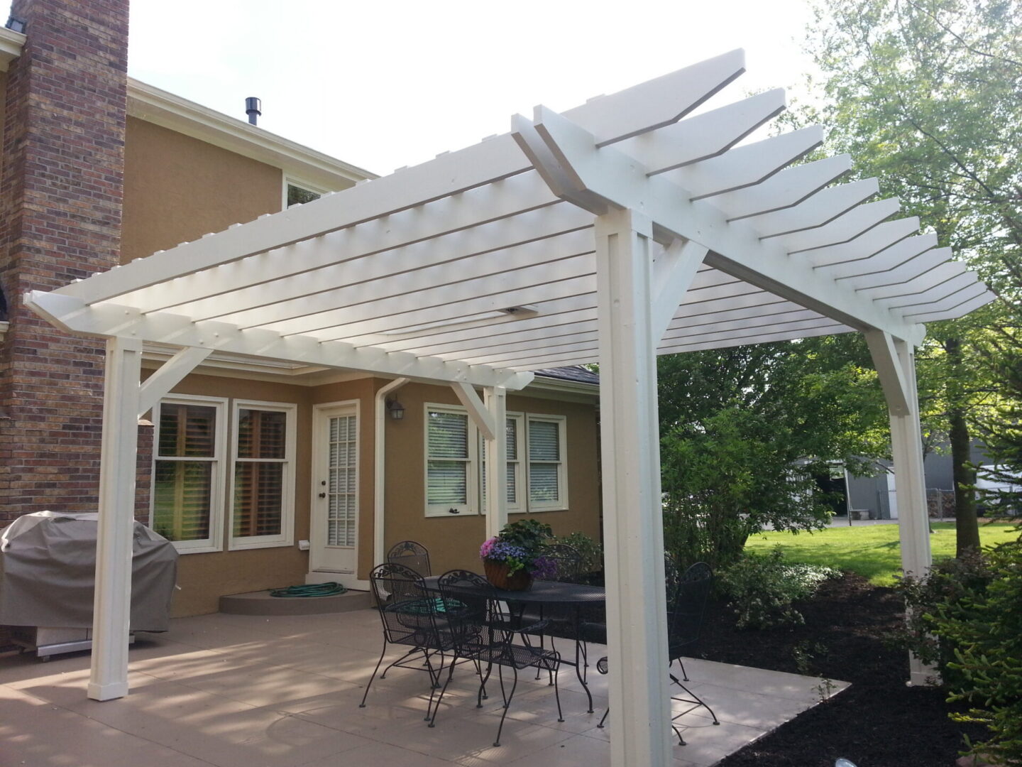 White backyard pergola over patio dining set